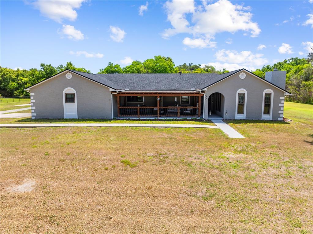A single-story gray house features a covered front porch and a concrete walkway — 233 EASTERN AVENUE, ST CLOUD, FL