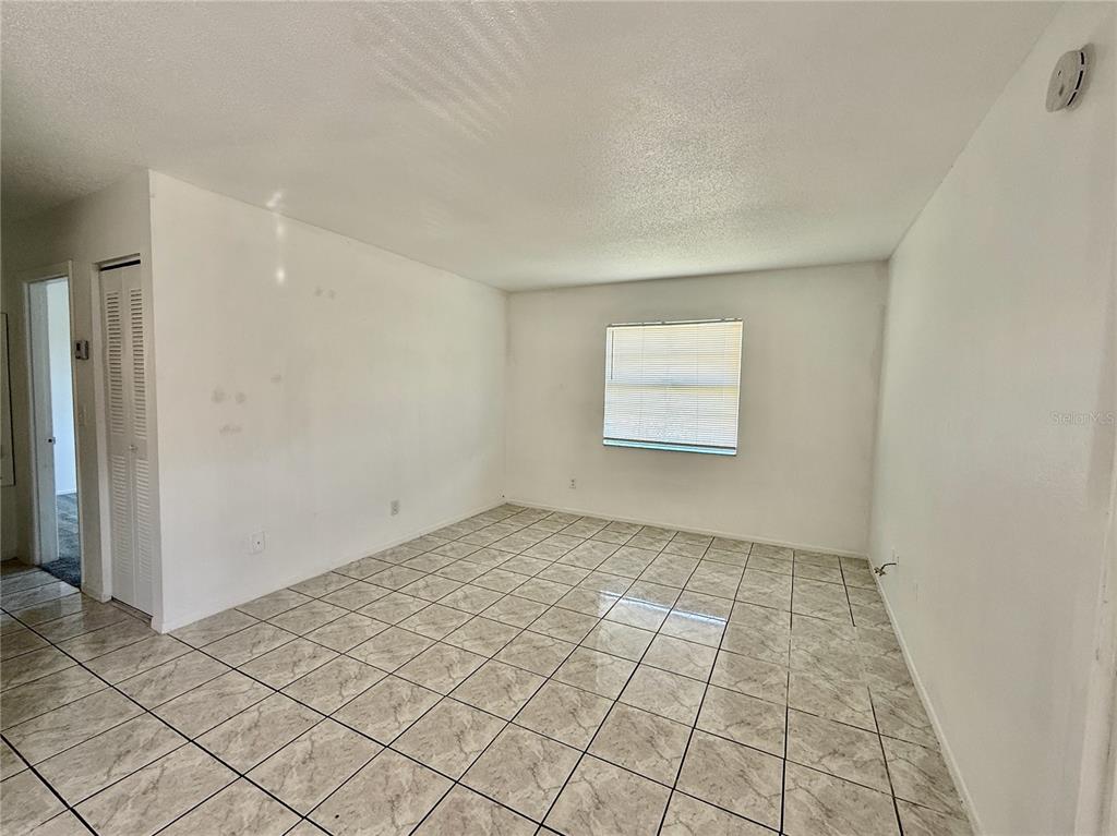 An empty room with white walls, a single window, and light-colored tiled flooring — 733 MICHIGAN COURT UNIT 4, ST CLOUD, FL