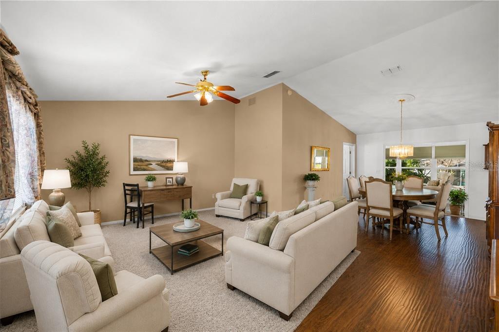 A living room and dining area with beige walls, carpeted floors, and a ceiling fan — 13646 SE 91ST COURT, SUMMERFIELD, FL