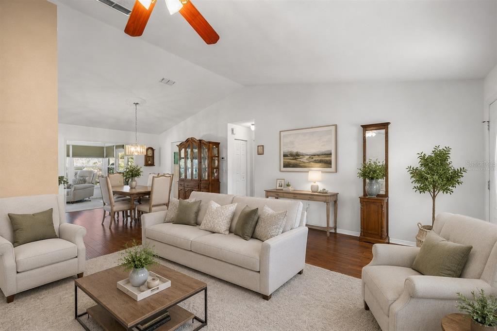 A living room with light-colored furniture, hardwood floors, a ceiling fan, and an adjacent dining area — 13646 SE 91ST COURT, SUMMERFIELD, FL