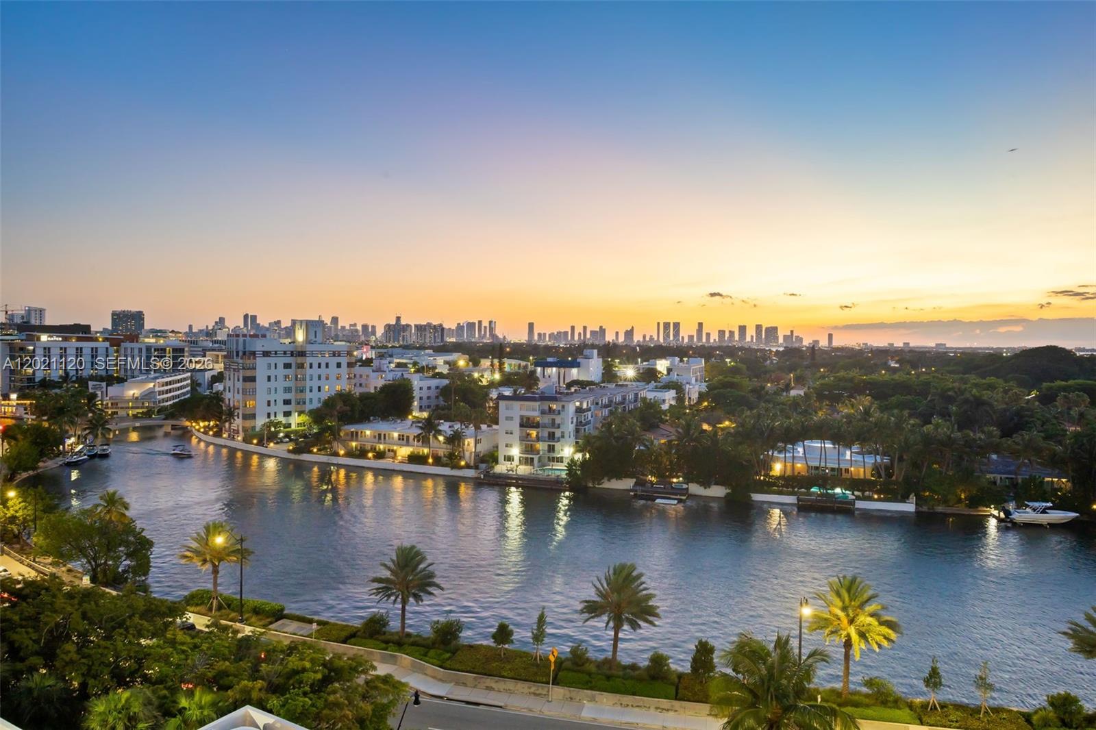 An elevated view of a canal lined with palm trees and buildings at sunset — 2555 Collins Ave # 1106, Miami Beach FL 33140, MIAMI BEACH, FL
