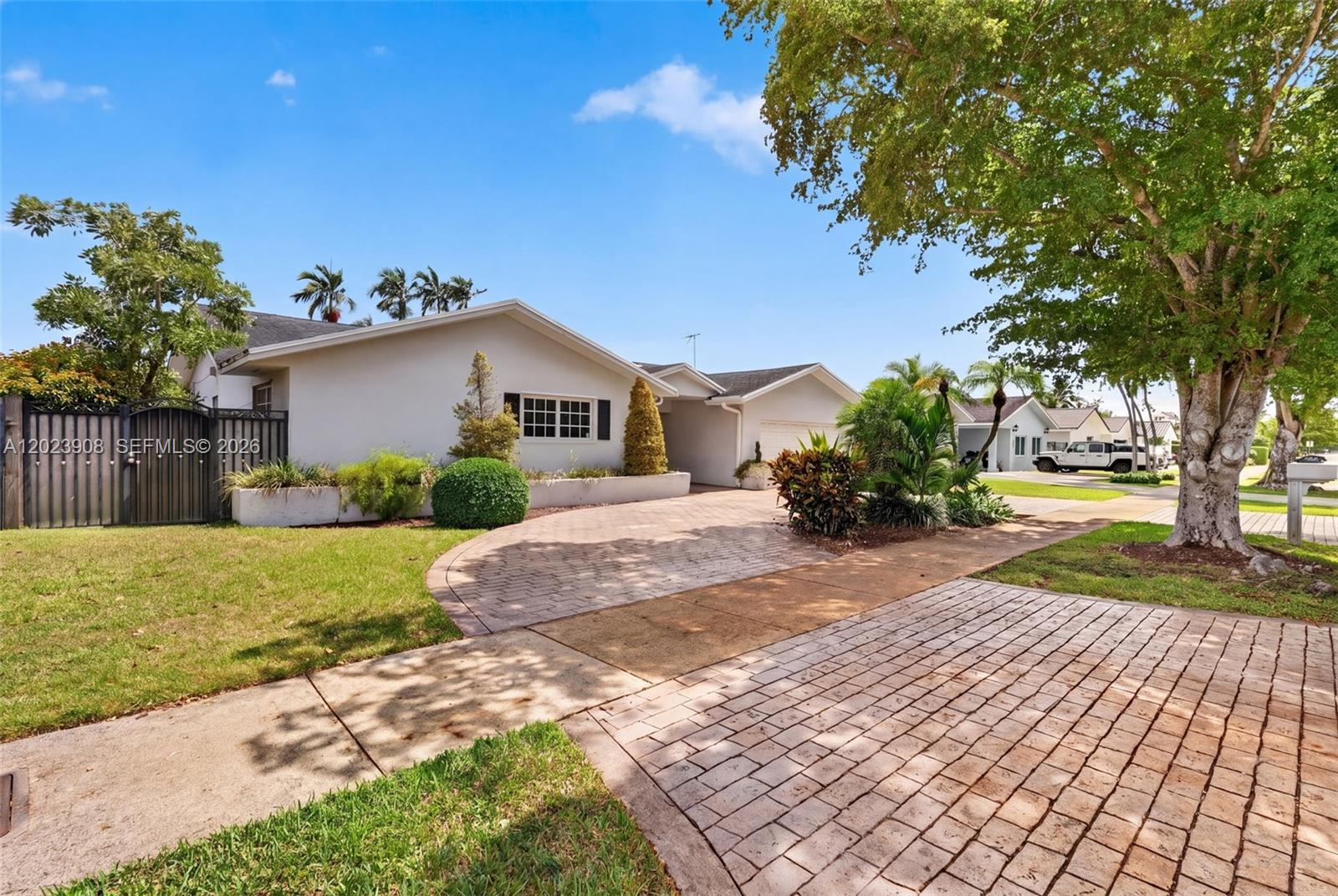 A single-story house with a paved driveway and landscaped front yard under a blue sky — 14001 SW 108th St, Miami FL 33186, MIAMI, FL