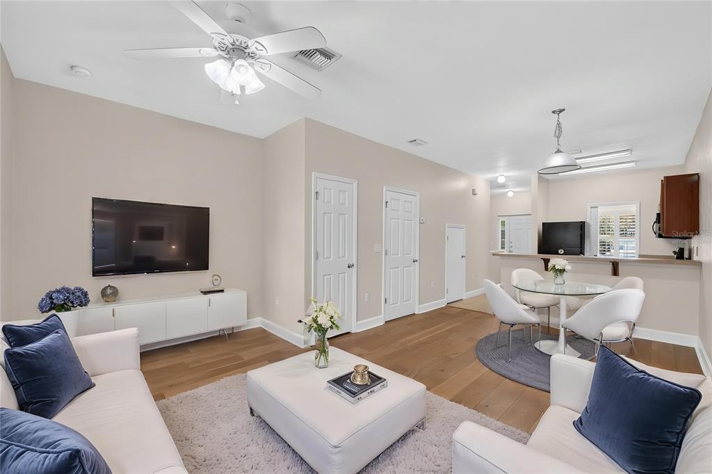A living room with a white sofa, central ottoman, and an adjacent dining area — 2927 SW 35TH PLACE UNIT 115, GAINESVILLE, FL