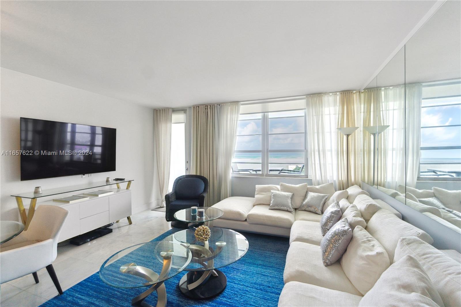 A living room features a white sectional sofa, blue area rug, and ocean views — 100 Lincoln Rd # 1534, Miami Beach FL 33139, MIAMI BEACH, FL