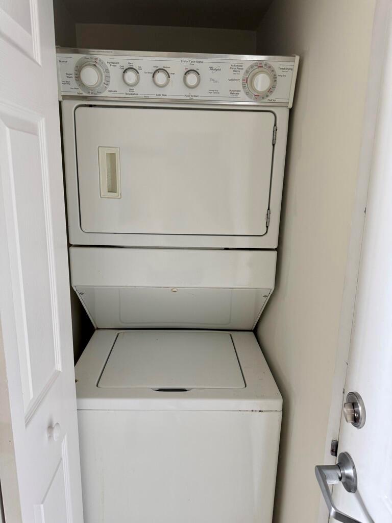 A stacked white washer and dryer unit located inside a small closet — 3000 Coral Way # 1007, Miami FL 33145, MIAMI, FL