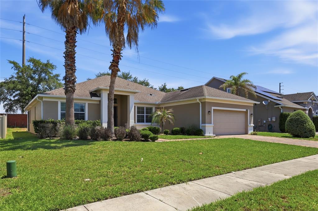A single-story suburban house with a tan exterior, a two-car garage, and two palm trees — 3316 MCCORMICK WOODS DRIVE, OCOEE, FL
