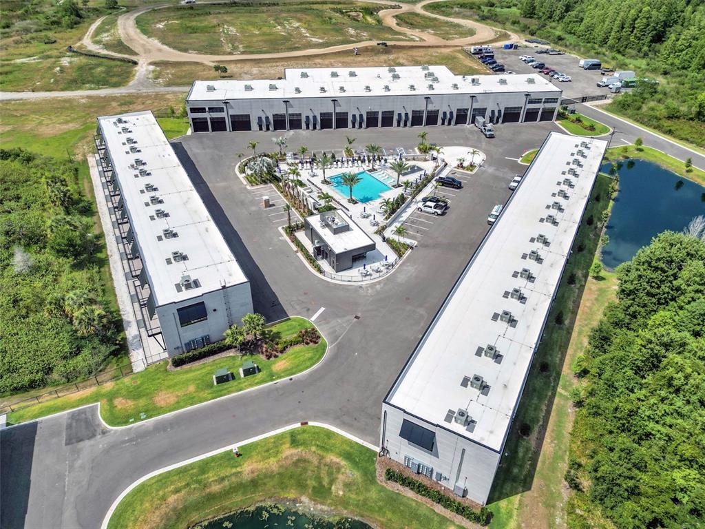 Aerial view of a commercial complex with three buildings surrounding a central pool and parking — 6500 MOTOR ENCLAVE WAY UNIT 1214, TAMPA, FL