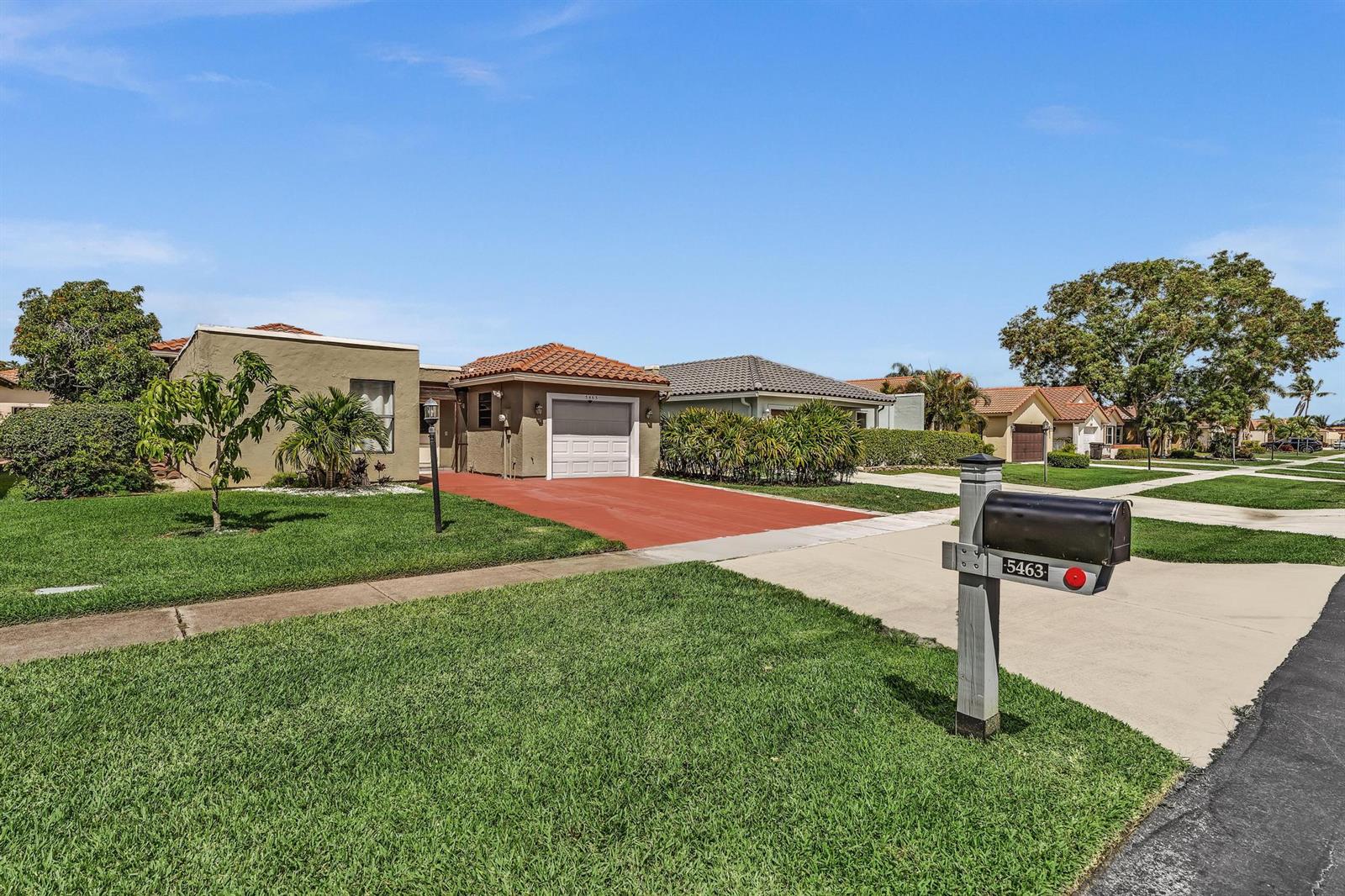 A single-story house with a red driveway and a mailbox in the foreground — 5463 Alta Way, Lake Worth FL 33467, LAKE WORTH, FL