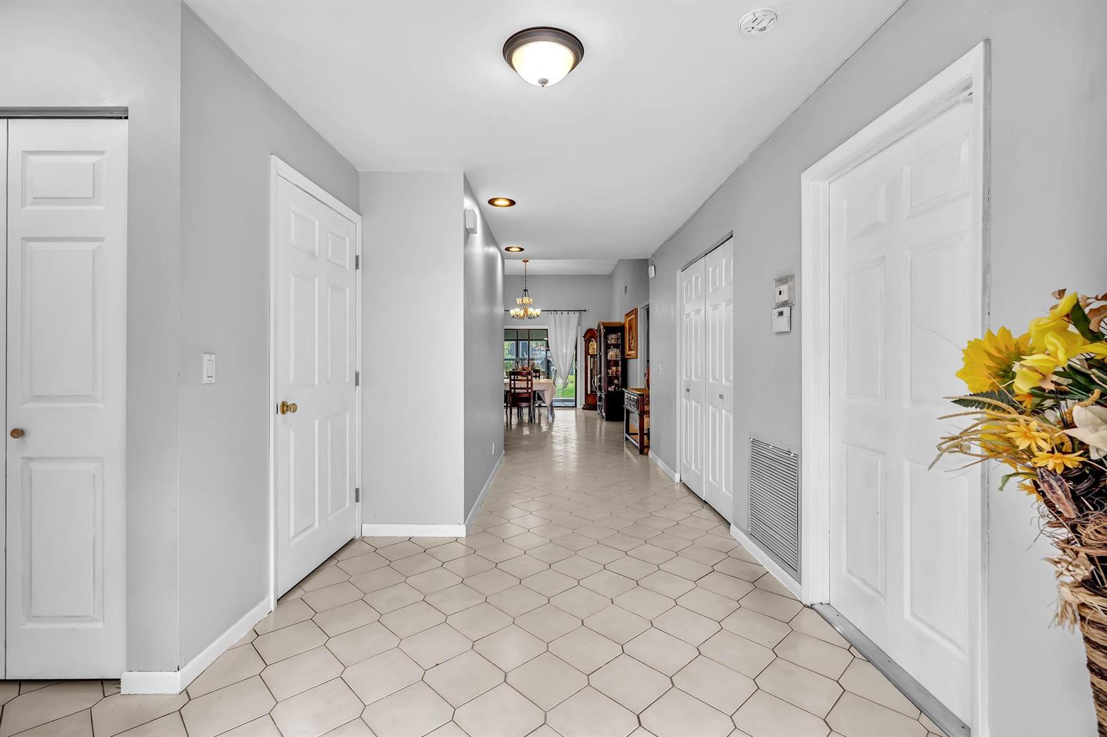A tiled hallway leads from the entryway toward a dining area with light gray walls — 5463 Alta Way, Lake Worth FL 33467, LAKE WORTH, FL