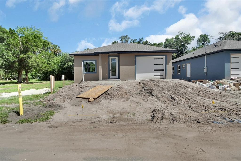 A newly constructed single-story house with a garage and unfinished dirt yard — 556 WALLACE STREET, DAYTONA BEACH, FL