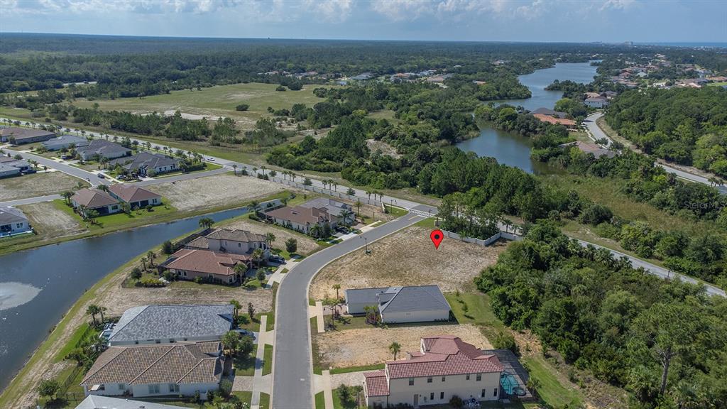 An aerial view shows a vacant residential lot marked with a red pin near houses — 2 RIO VISTA DRIVE, PALM COAST, FL