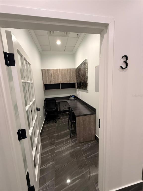 A small office with a desk, chair, upper cabinets, and dark marble-patterned flooring — 7901 KINGSPOINTE PARKWAY UNIT 19 #Office 3, ORLANDO, FL