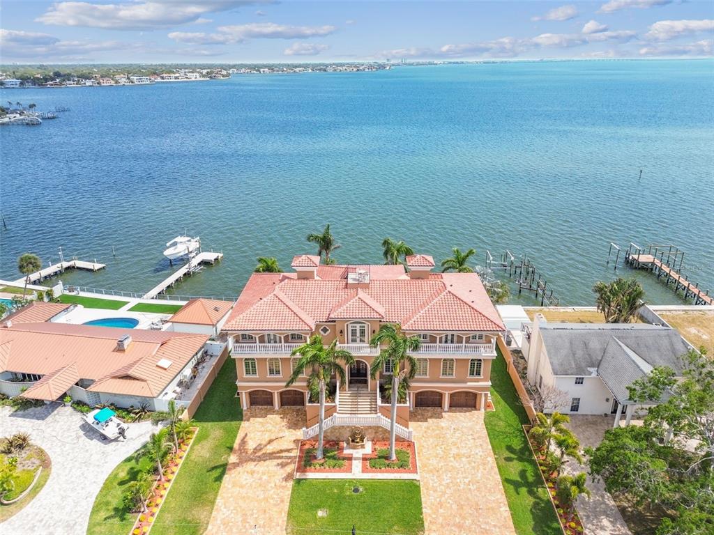 An aerial view of a multi-story waterfront mansion with a tile roof and boat docks — 5810 MARINER STREET, TAMPA, FL