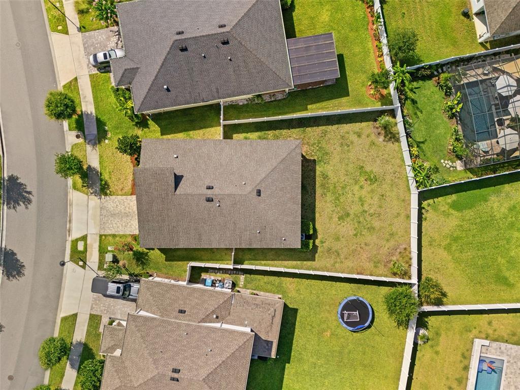 An aerial view shows three suburban houses with fenced backyards and a small trampoline — 9008 EXPLORATION AVENUE, ORLANDO, FL