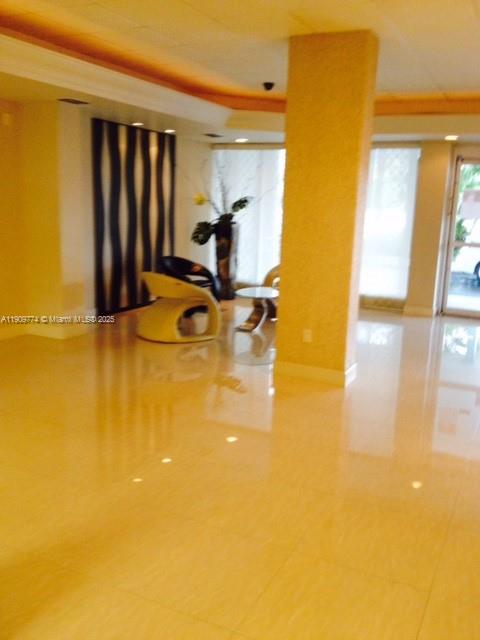 A bright lobby features polished tile floors, a central support column, and modern seating — 1833 S Ocean Dr # 308, Hallandale Beach FL 33009, HALLANDALE BEACH, FL