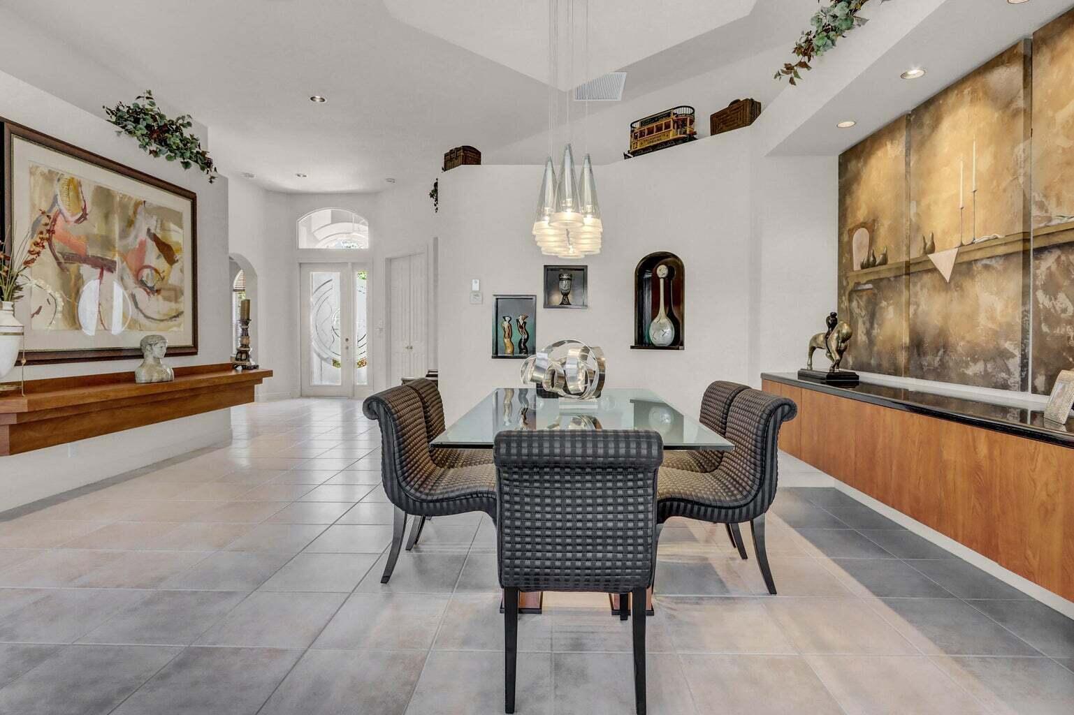 A dining room features a glass table, patterned chairs, tile flooring, and wood cabinetry — 6255 NW 42nd Way, Boca Raton FL 33496, BOCA RATON, FL