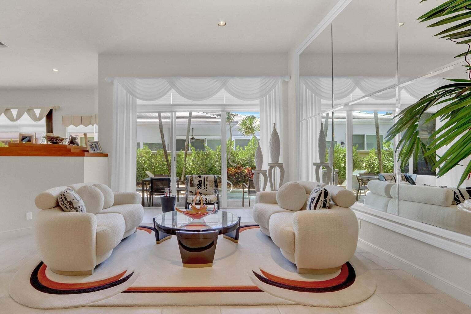 A living room features two cream sofas, a glass coffee table, and large mirrored walls — 6255 NW 42nd Way, Boca Raton FL 33496, BOCA RATON, FL