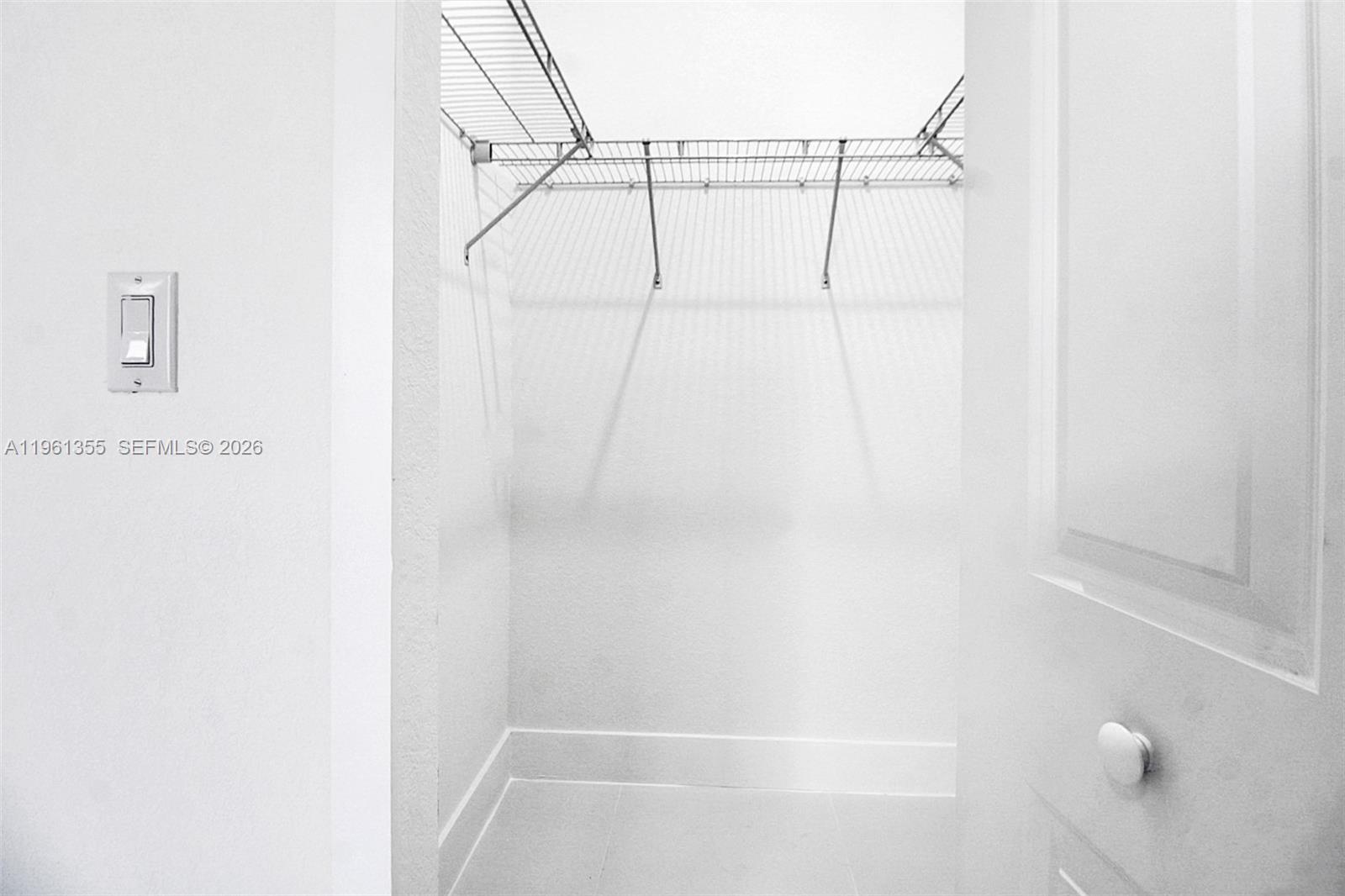 A small walk-in closet features white walls, tile flooring, and wire shelving — 20833 SW 96th Ct, Cutler Bay FL 33189, CUTLER BAY, FL