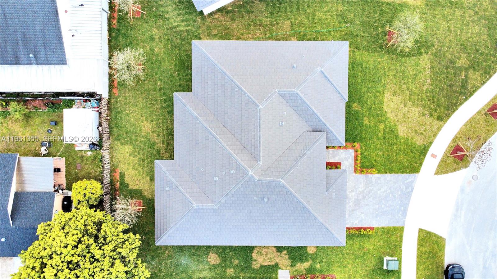 An aerial view shows the gray shingled roof of a house surrounded by a lawn — 20833 SW 96th Ct, Cutler Bay FL 33189, CUTLER BAY, FL