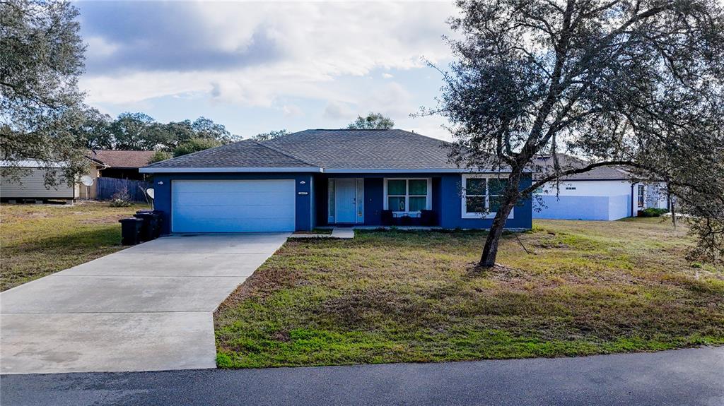 A single-story blue house with a two-car garage and a concrete driveway — 16417 SW 27TH CIRCLE, OCALA, FL