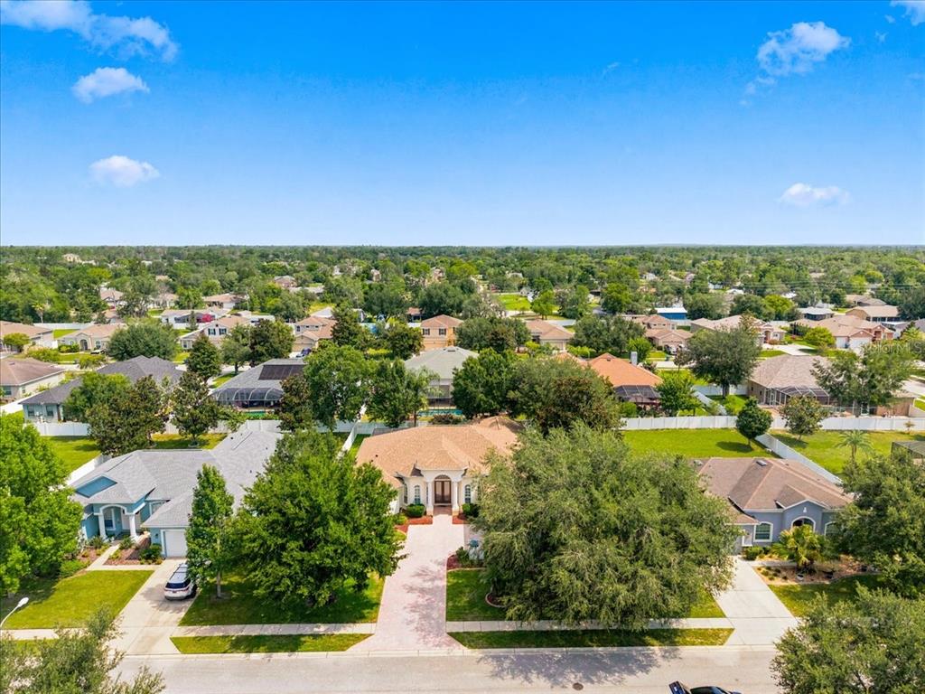 An aerial view of a suburban neighborhood featuring a single-story house with a paved driveway — 13519 BARKINGSIDE PLACE, SPRING HILL, FL