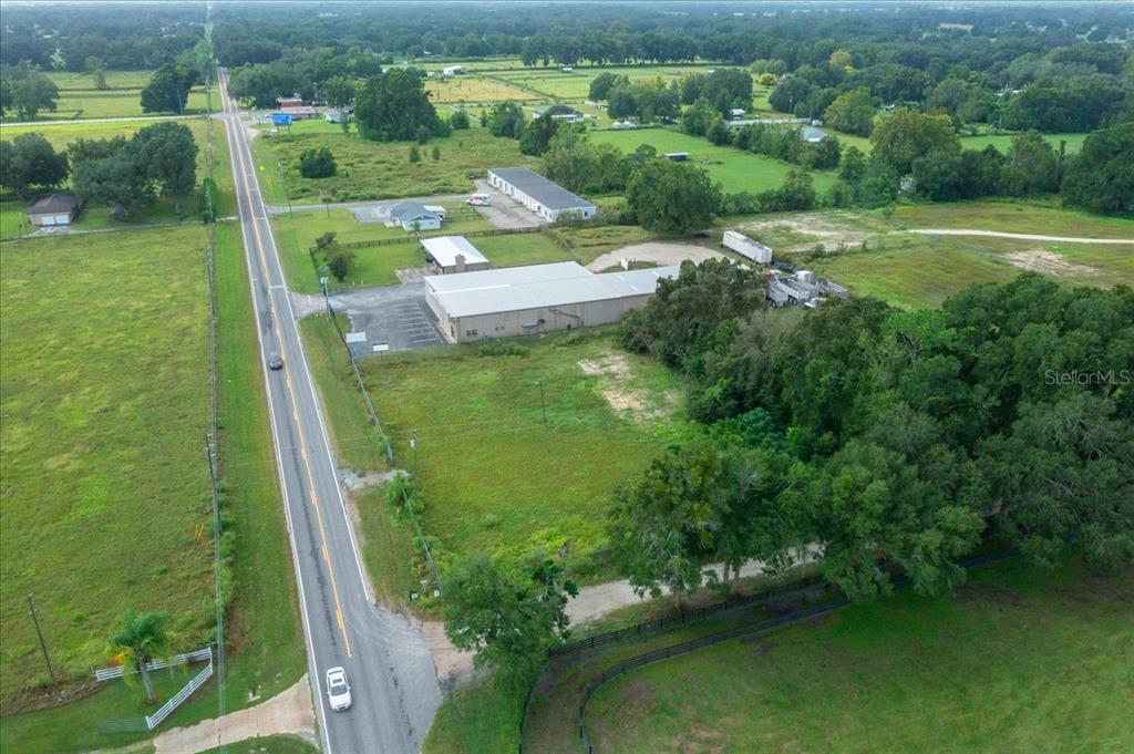 An aerial view shows a commercial building with a parking lot beside a rural road — 16262 S HIGHWAY 475, SUMMERFIELD, FL