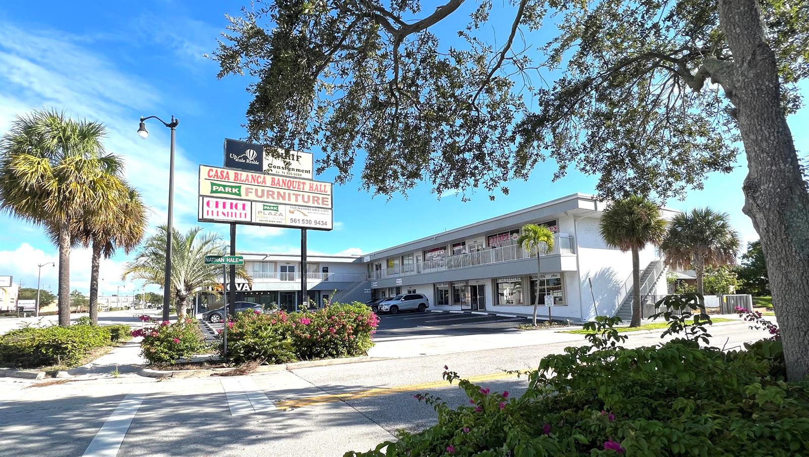 A two-story commercial plaza with a large sign stands near a parking lot and trees — 6230 S Dixie Highway # B, West Palm Beach FL 33405, WEST PALM BEACH, FL