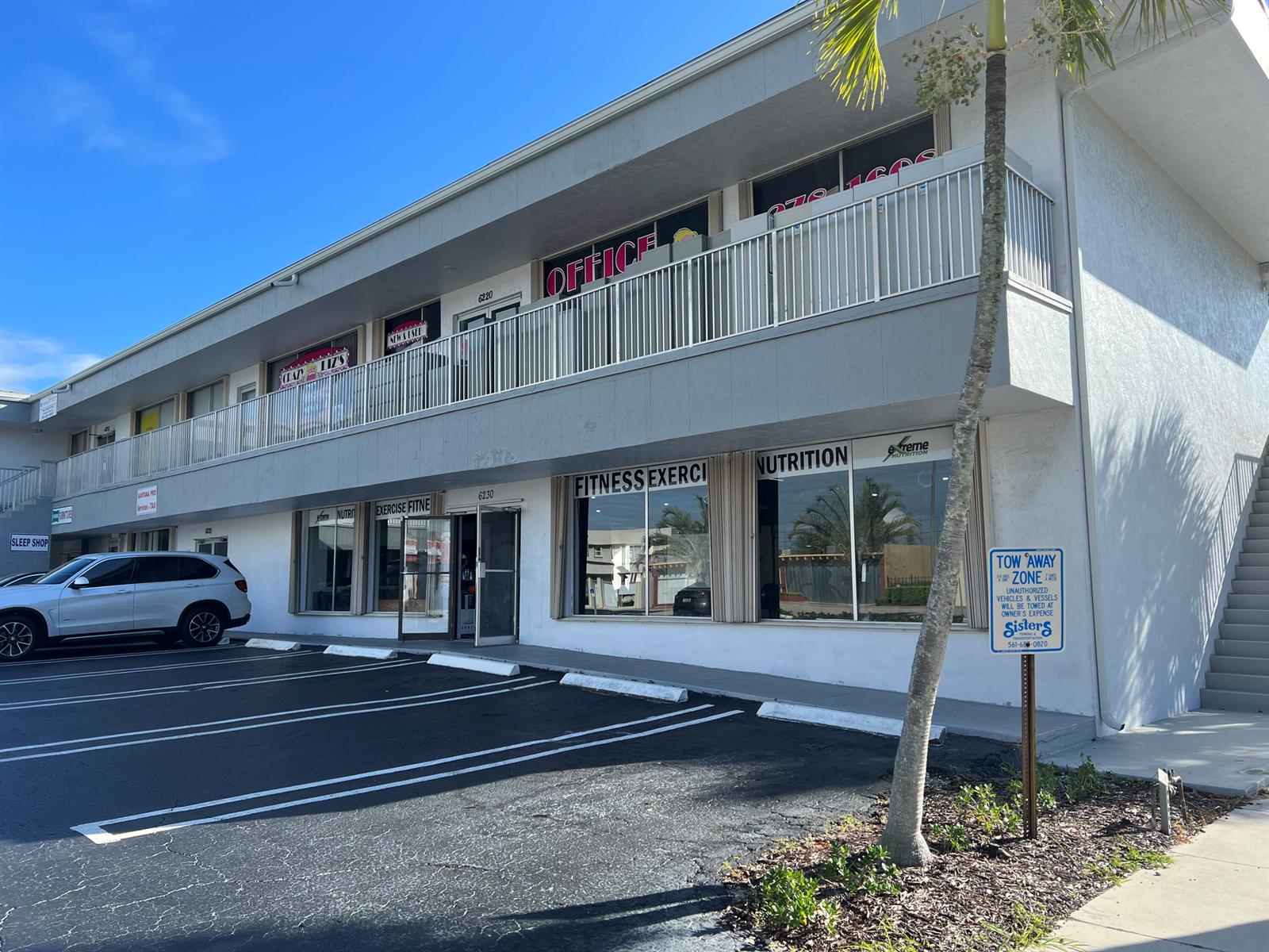 A two-story commercial building with a parking lot, a balcony, and storefront signage — 6230 S Dixie Highway # B, West Palm Beach FL 33405, WEST PALM BEACH, FL