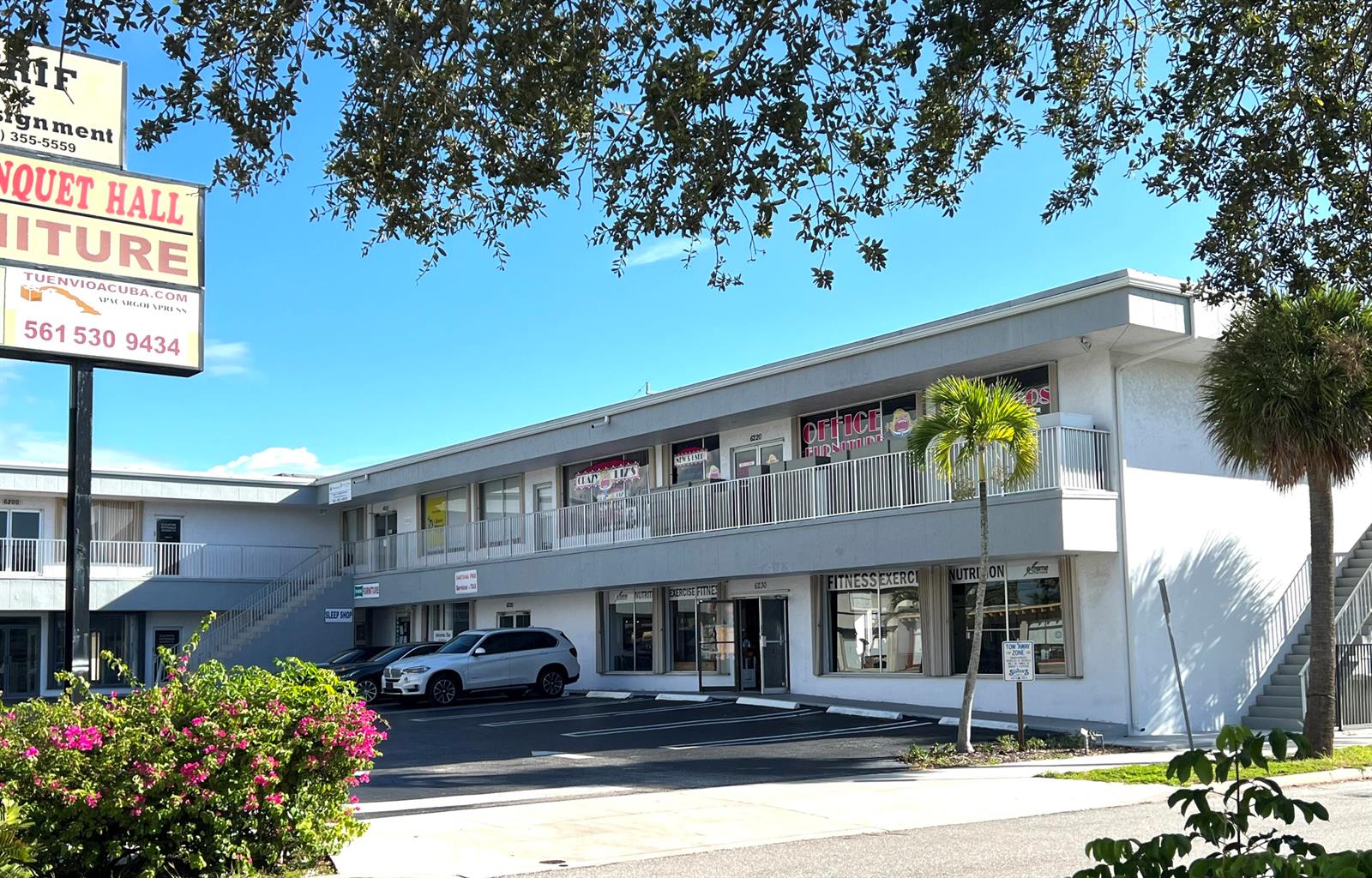 A two-story commercial building features a parking lot, exterior staircases, and various storefronts — 6230 S Dixie Highway # B, West Palm Beach FL 33405, WEST PALM BEACH, FL