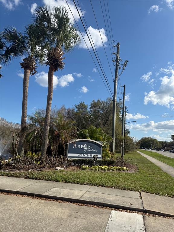 A sign for Arbors of Sendera stands near palm trees and a sidewalk along a road — 3827 BAY CLUB CIRCLE UNIT 103, KISSIMMEE, FL