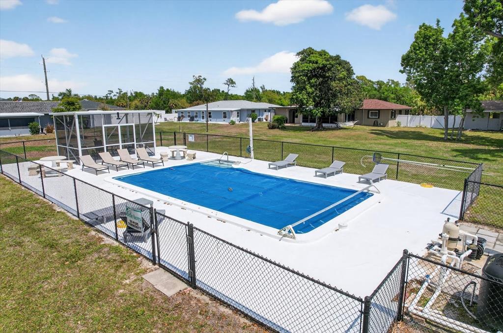 An outdoor swimming pool with a blue cover is enclosed by a chain-link fence — 4075 DRANCE STREET, PUNTA GORDA, FL
