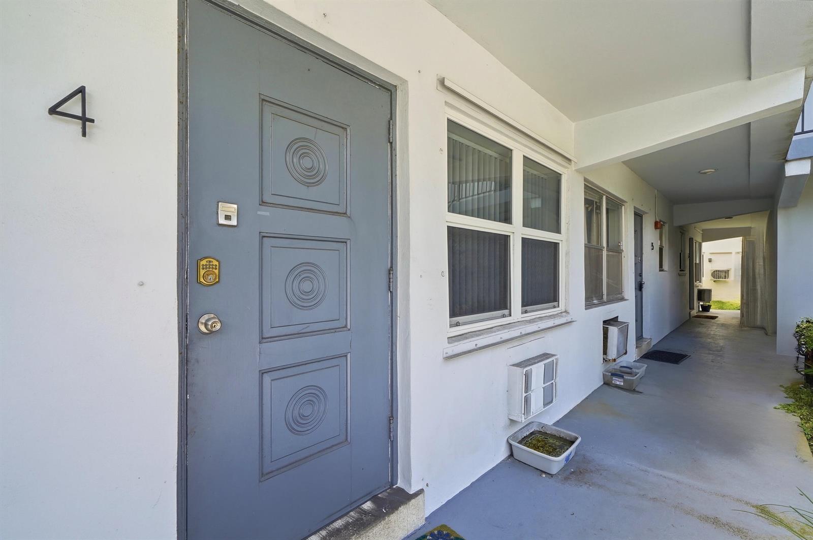 A gray door with the number four sits on a concrete walkway beside a window — 3510 Harrison Street # 4, Hollywood FL 33021, HOLLYWOOD, FL