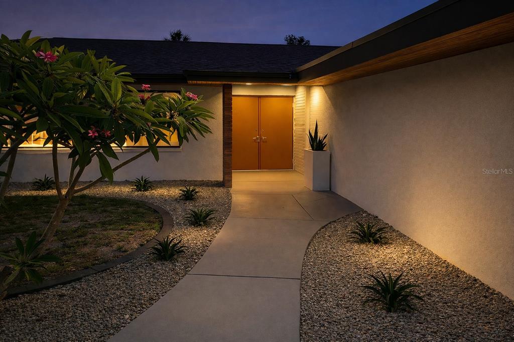 A concrete walkway leads to double orange front doors at the entrance of a house — 1901 UPPER COVE TERRACE, SARASOTA, FL