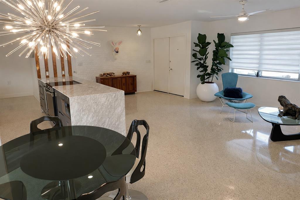 A modern open-concept kitchen and living area featuring a starburst chandelier and terrazzo flooring — 1901 UPPER COVE TERRACE, SARASOTA, FL