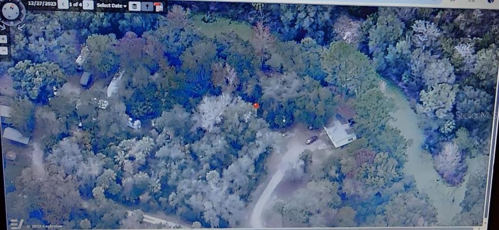 This aerial view shows a house and several outbuildings situated on a wooded, rural lot — 0000 NE 164TH PLACE E, CITRA, FL