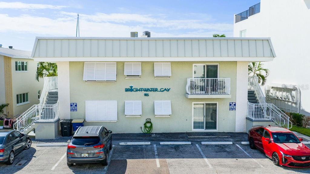 An exterior view of a two-story apartment building with a parking lot in front — 185 BRIGHTWATER DRIVE UNIT 4, CLEARWATER BEACH, FL