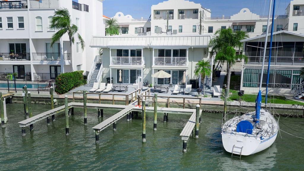 An aerial view of a waterfront townhouse with a private dock and a docked sailboat — 185 BRIGHTWATER DRIVE UNIT 4, CLEARWATER BEACH, FL