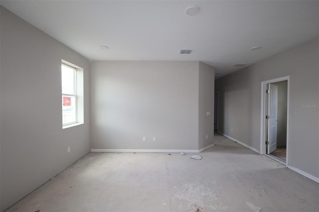 An unfinished room with light gray walls, a single window, and a doorway — 1359 LUMPINI STREET, ST CLOUD, FL