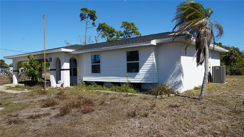 A single-story white house with a covered porch, a palm tree, and an air conditioner — 3552 MIDDLETOWN STREET, PORT CHARLOTTE, FL