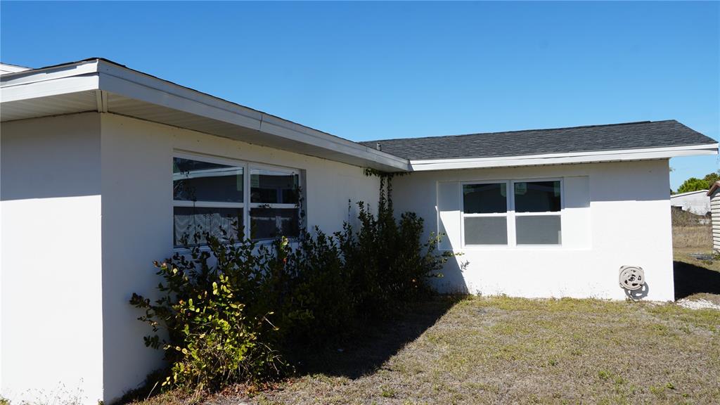 The exterior of a white house features a dark shingled roof and two windows — 3552 MIDDLETOWN STREET, PORT CHARLOTTE, FL