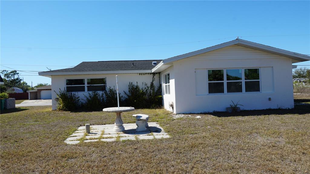 A white single-story house with a patio table and chairs on a grassy lawn — 3552 MIDDLETOWN STREET, PORT CHARLOTTE, FL