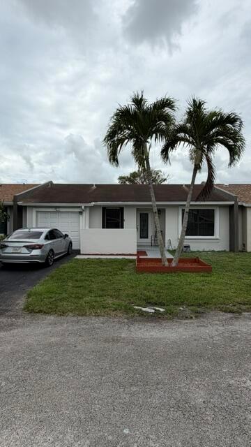 A single-story house with a white garage, a front lawn, and two tall palm trees — 5460 S Lakewood Cir S # C, Margate FL 33063, MARGATE, FL