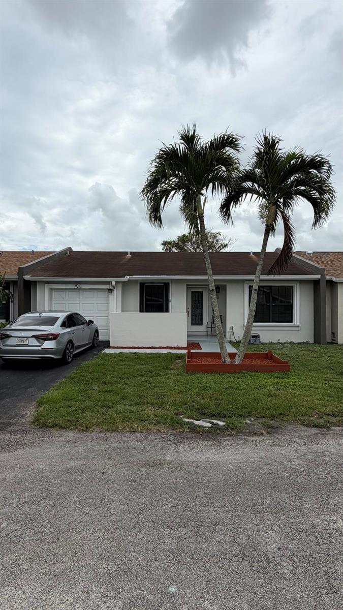 A single-story house with a white exterior, a garage, and two palm trees in front — 5460 S Lakewood Cir S # C, Margate FL 33063, MARGATE, FL