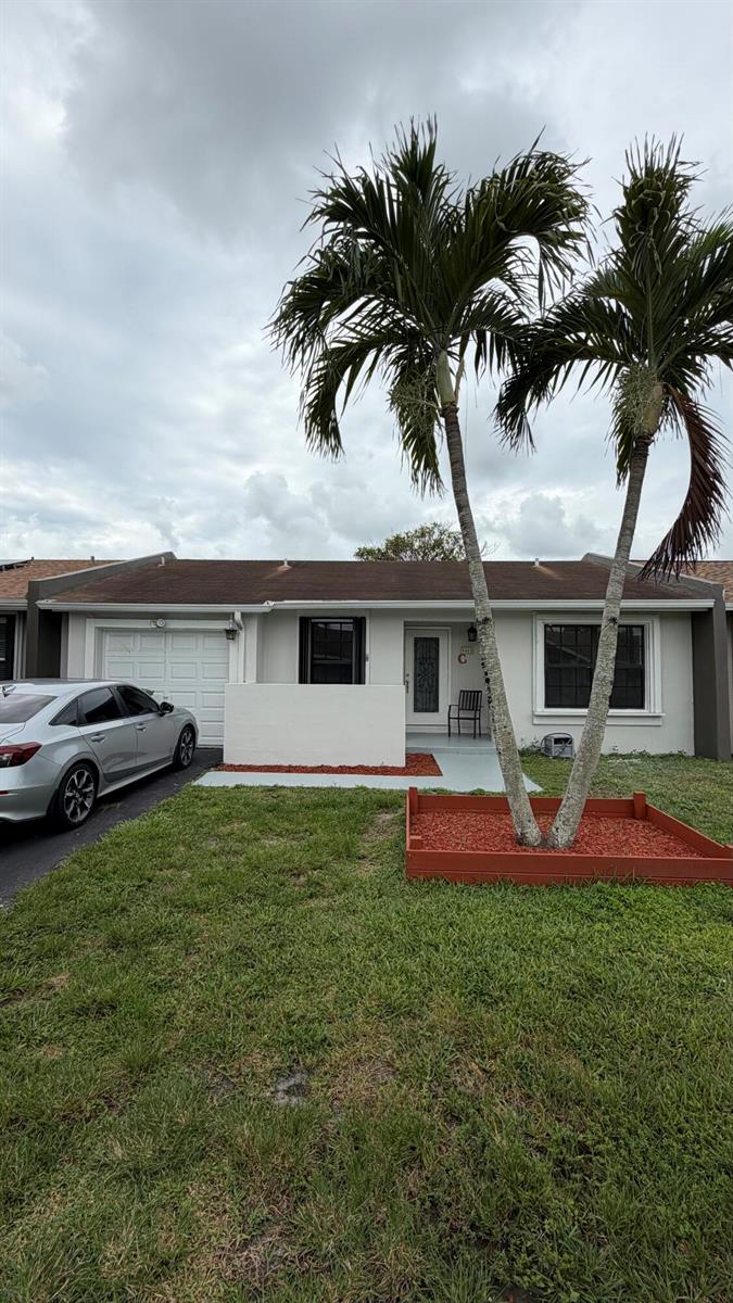 A single-story house with a white exterior, a garage, and two palm trees in front — 5460 S Lakewood Cir S # C, Margate FL 33063, MARGATE, FL