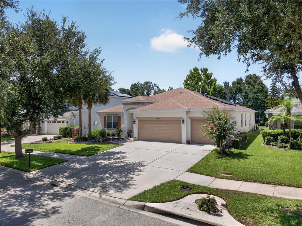 A single-story suburban house with a tan garage and a concrete driveway — 15601 STARLING WATER DRIVE, LITHIA, FL