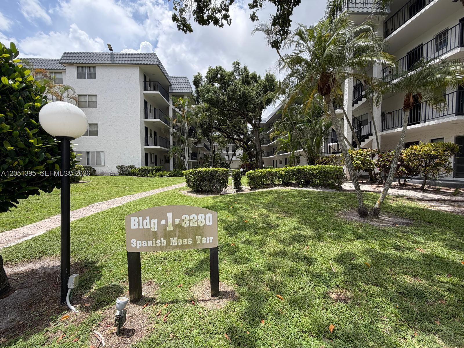 A sign for building 3280 stands on a grassy lawn between two multi-story apartment buildings — 3280 Spanish Moss Ter # 110, Lauderhill FL 33319, LAUDERHILL, FL