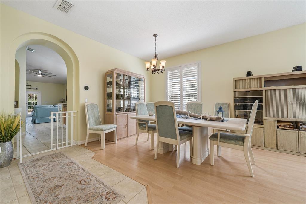 A dining room features a light wood table, matching chairs, a hutch, and tile flooring — 2248 HILLSHIRE DRIVE, ORLANDO, FL