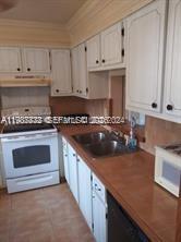 A kitchen features white cabinets, a white stove, a double sink, and brown countertops — 620 NE 12th Ave # 408, Hallandale Beach FL 33009, HALLANDALE BEACH, FL
