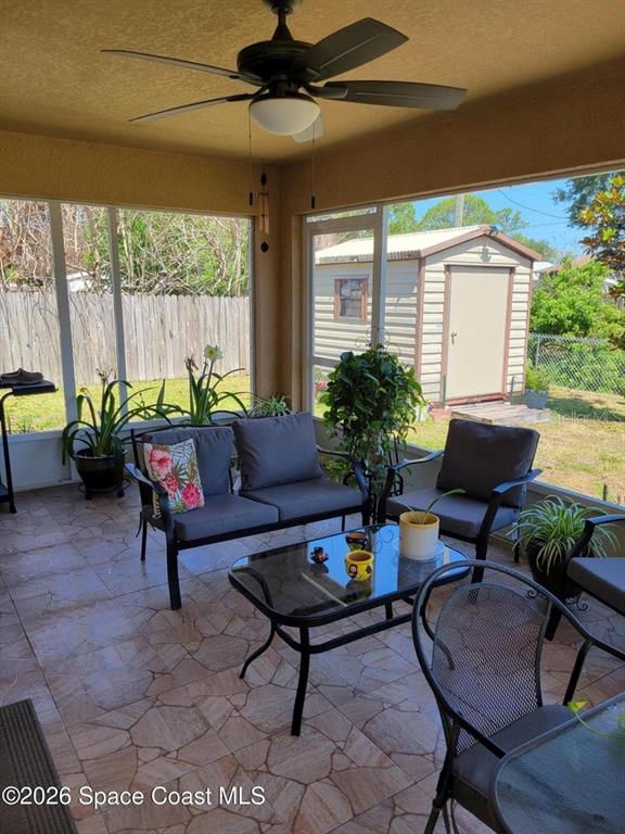 A screened-in patio features tiled flooring, patio furniture, a ceiling fan, and a backyard shed — 1703 VALCOURT STREET NW, PALM BAY, FL