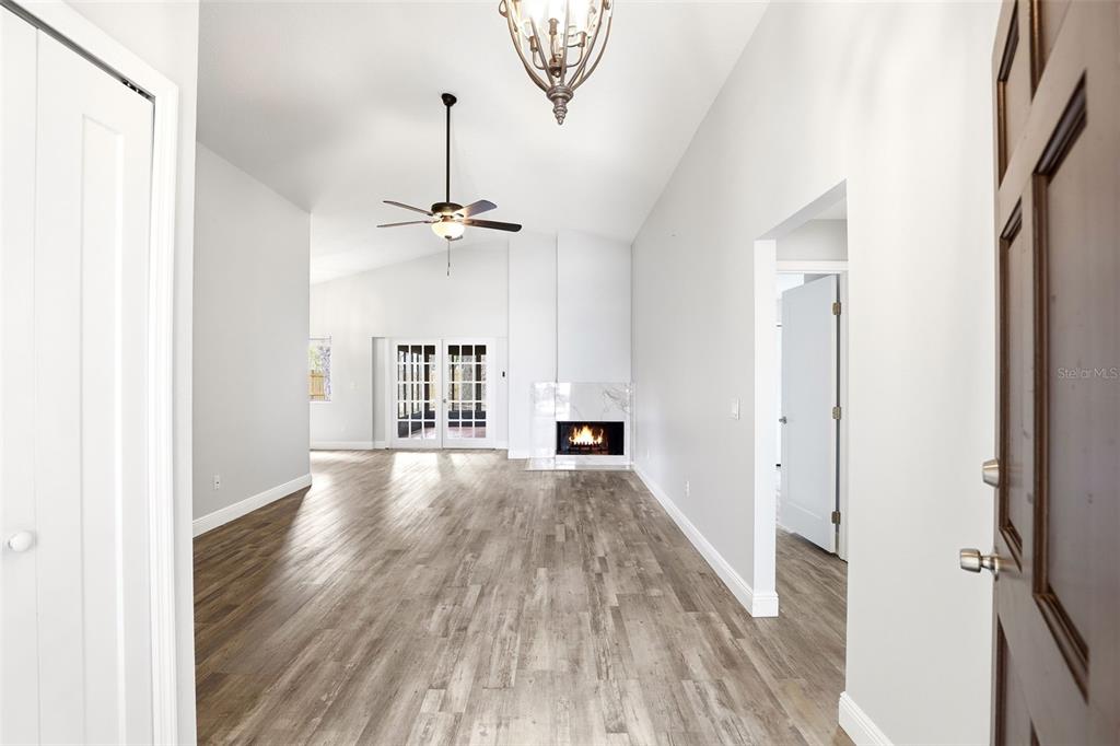 A living room features light wood flooring, a fireplace, a ceiling fan, and vaulted ceilings — 444 MORNING GLORY DRIVE, LAKE MARY, FL